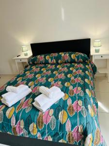 ein Schlafzimmer mit einem Bett mit zwei Handtüchern darauf in der Unterkunft THE HOUSE FIERA di ROMA in Ponte Galeria