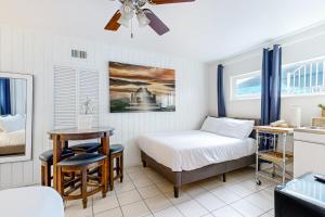 Schlafzimmer mit einem Bett, einem Schreibtisch und einem Tisch in der Unterkunft Balboa Beauty III in Newport Beach