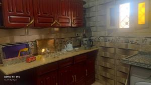 a kitchen with red cabinets and a counter top at Amon guest house in Abu Simbel