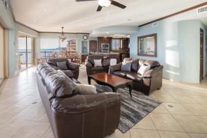 uma sala de estar com sofás de couro e uma mesa em Sonoran SKY #910 em Puerto Peñasco