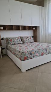 een bed in een slaapkamer met een wit bedframe bij La casa del sole a 50 m dal mare in Lido di Camaiore