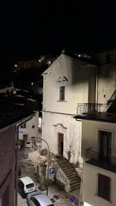 a white building with a car parked in a parking lot at La casa del fumetto in Castel di Sangro