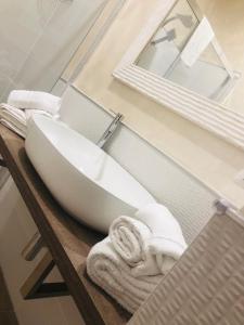 bagno con lavandino bianco e specchio di Lilli's Home ad Ascoli Piceno
