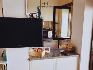 a kitchen with a counter top with a tv on it at Mira'Barrinha Flats in Praia de Mira +20 photos