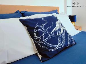 a bed with a pillow with an octopus on it at Mira'Barrinha Flats in Praia de Mira