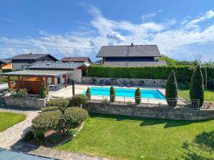 een huis met een zwembad in een tuin bij GLÜCKSMOMENT - beeindruckende Ferienwohnung mit Pool in Seekirchen am Wallersee