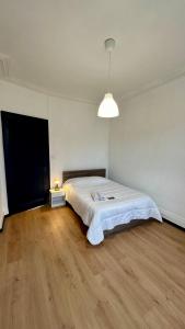 a bedroom with a large bed in a room with wooden floors at Appartement F5 proche centre ville in Mulhouse