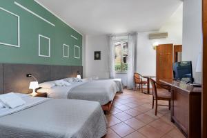 Habitación de hotel con 2 camas y escritorio en Comfort Rooms Villa Gaia Tor Vergata, en Roma