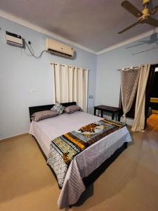 a bedroom with a bed and a ceiling fan at MOA Auroville pondicherry in Auroville