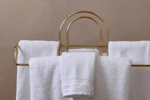 a gold towel rack with white towels on it at Designer King Studio Private Curated Cottage in Cottonwood +47 photos