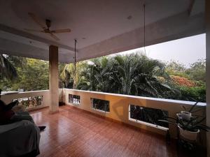 a living room with a ceiling fan and a large window at MOA Auroville pondicherry in Auroville