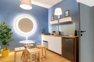 - une cuisine avec des murs bleus, une table et des chaises dans l'établissement Rialto 13, à Trévise