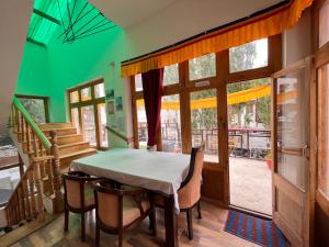 d'un balcon et d'une salle à manger avec une table et des chaises. dans l'établissement Safarnama Homestay Leh - Best Rooms in Leh with Parking, à Leh