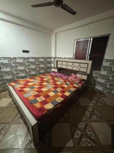 a bedroom with a bed with a quilt on it at GRG Sunrise Plaza Deoghar in Deoghar