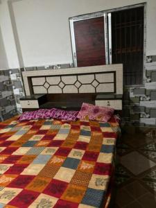 a bedroom with a bed with a colorful quilt at GRG Sunrise Plaza Deoghar in Deoghar