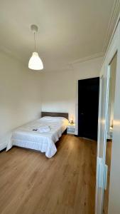 a bedroom with a large bed with a wooden floor at Appartement F5 proche centre ville in Mulhouse