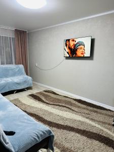 um quarto com uma foto de um homem e uma mulher em Муканова 6/2 em Karaganda