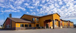 un edificio amarillo con un cielo con nubes en Quality Inn Indianola, en Indianola