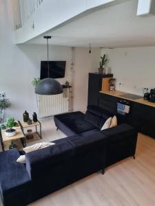 a living room with a black couch and a table at Private 3 bedroom apartment - HomeStay Properties Amsterdam in Amsterdam