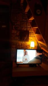 einen TV auf einem Tisch neben einer Lampe in der Unterkunft Tarski Proplanak in Bajina Bašta