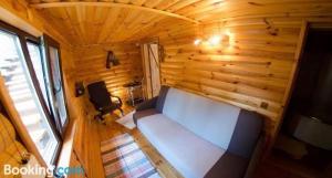 a small room with a bed in a wooden cabin at California in Khorodelets