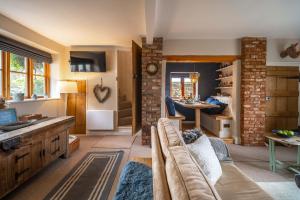 a living room with a couch and a table at Samphire Cottage by Big Skies Cottages in Docking