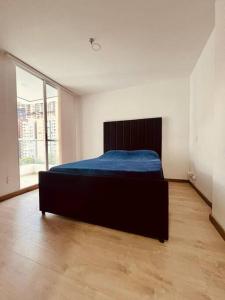 ein Schlafzimmer mit einem Bett mit einer blauen Decke darauf in der Unterkunft Medellin: Cozy Apat with City View in Envigado