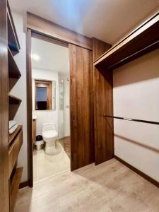 ein Badezimmer mit WC und ein Badezimmer mit Tür in der Unterkunft Medellin: Cozy Apat with City View in Envigado