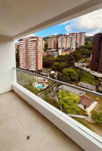 einen Balkon mit Blick auf eine Stadt mit hohen Gebäuden in der Unterkunft Medellin: Cozy Apat with City View in Envigado