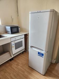 a white refrigerator in a kitchen with a microwave at 88 in Wolverton
