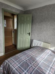 sypialnia z łóżkiem i zielonymi drzwiami w obiekcie 88 w mieście Wolverton