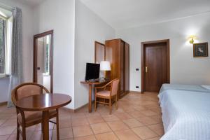 Habitación de hotel con cama y escritorio con ordenador en Comfort Rooms Villa Gaia Tor Vergata, en Roma