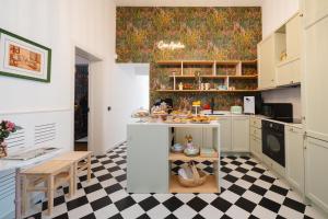 cocina con armarios blancos y suelo a cuadros en Casa Apuliae Bed & breakfast, en Bitonto