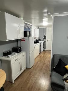 a small kitchen with white cabinets and a table at All Seasons Chalet Breaks in Leysdown-on-Sea