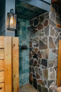 a bathroom with a stone wall and a light fixture at Rivers Ledge - 62 Acre Nature Retreat in Eldred