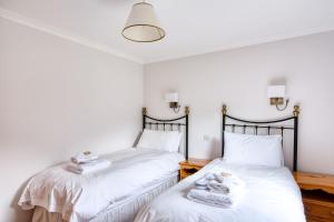 Camera con 2 letti singoli e pareti bianche. di Kingfisher Lodge sleeps up to 4 a Crianlarich