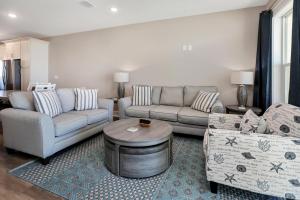 a living room with two couches and a table at Pelican's Perch by Pristine Properties Vacation Rentals in Saint Joe Beach