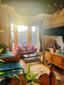 sala de estar con 2 camas y sofá en Rosehall Hotel, en Edimburgo