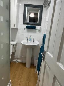 W łazience znajduje się umywalka, lustro i toaleta. w obiekcie All Seasons Chalet Breaks w mieście Leysdown-on-Sea