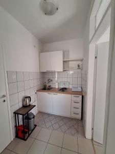 a small kitchen with white cabinets and a table at DIN Ljubic in Mimice
