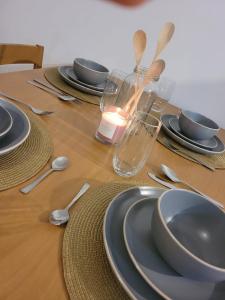 a wooden table topped with plates and bowls and spoons at Apartamento Bay View Panama cinta costera in Panama City