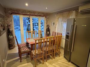 een keuken met een tafel en stoelen en een koelkast bij Rähni Guesthouse Lake Peipsi in Vilusi