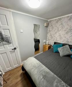 1 dormitorio con 1 cama con almohadas azules en All Seasons Chalet Breaks, en Leysdown-on-Sea