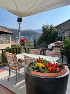 einen Tisch und Stühle auf einem Balkon mit einer Schüssel Blumen in der Unterkunft Hotel Villa Edera & La Torretta in Moneglia