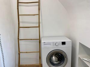 een wasruimte met een wasmachine en een ladder bij Appart T4 spacieux & lumineux proche de la mer in Guidel