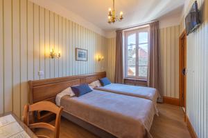Postel nebo postele na pokoji v ubytování Hotel De La Cloche