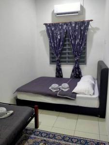 - une chambre avec un lit doté de rideaux bleus et d'une fenêtre dans l'établissement Uzma Homestay Kuala Sg Baru, Melaka, à Malacca