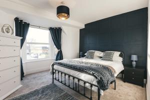 a bedroom with a bed with a black wall at House with a cinema and games room, sleeps 17 in Shrewsbury