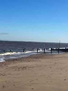 a beach with the ocean and a pier in the water at All Seasons Chalet Breaks in Leysdown-on-Sea
