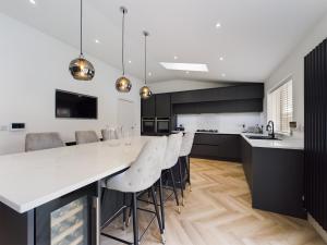 una cocina con una gran mesa blanca y sillas en Luxury Modern Spacious House, en Hull